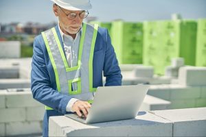man with a computer at a construction site