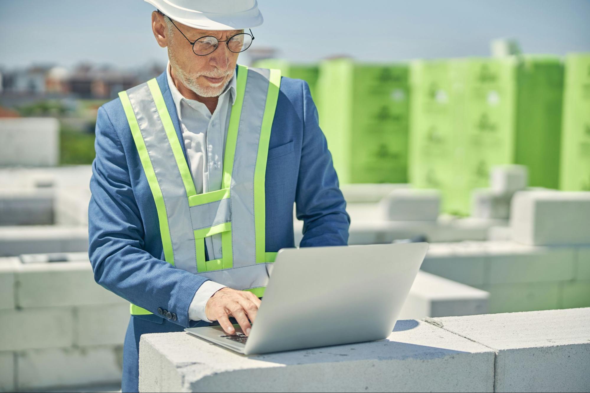 man with a computer at a construction site